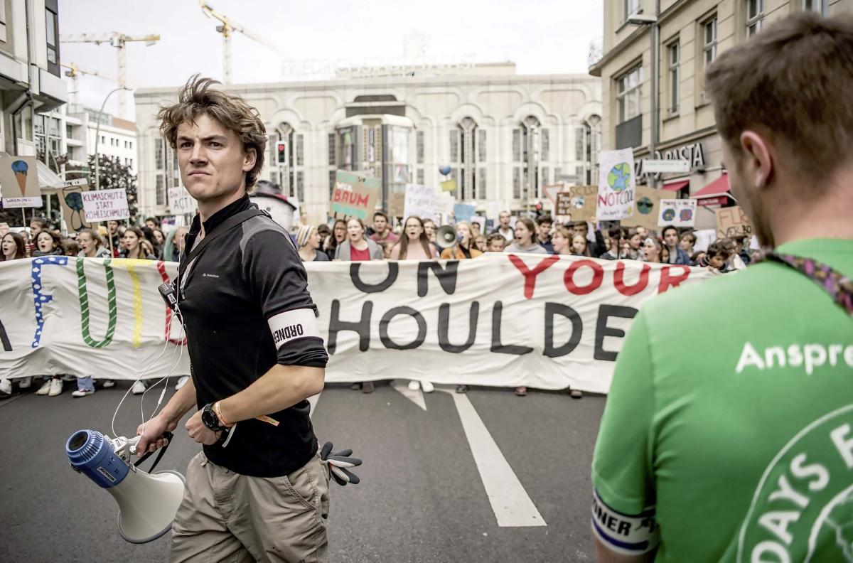 Ein Aktivist mit Megafon leitet eine Demonstration in den Straßen von Berlin an.