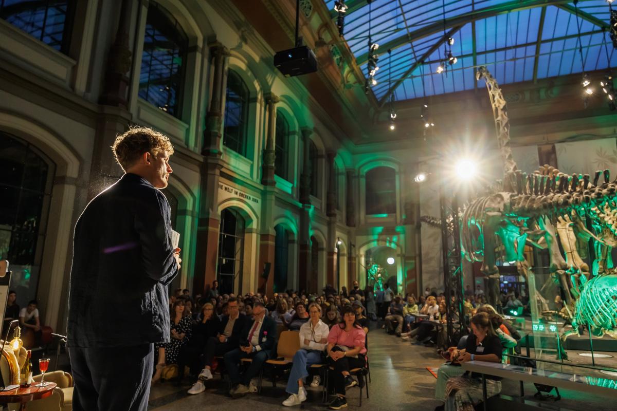 Moderator Lukas Klaschinski auf der Bühne im Sauriersaal Moderator Lukas Klaschinski auf der Bühne im Sauriersaal