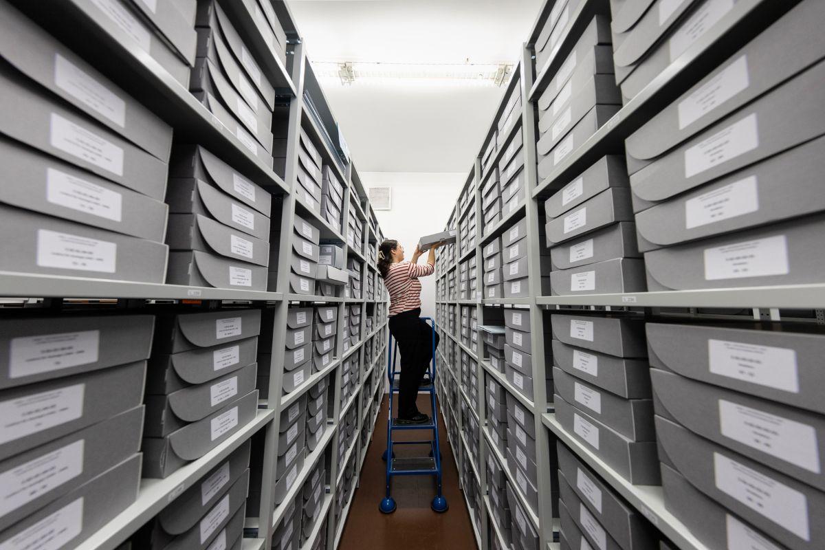 Person im Archiv auf einer Leiter Person im Archiv auf einer Leiter