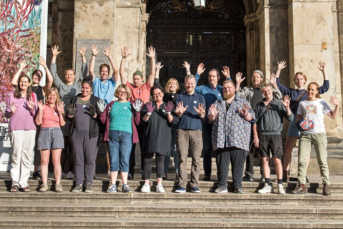 Group of people waving at the entrance to the Museum of Natural History