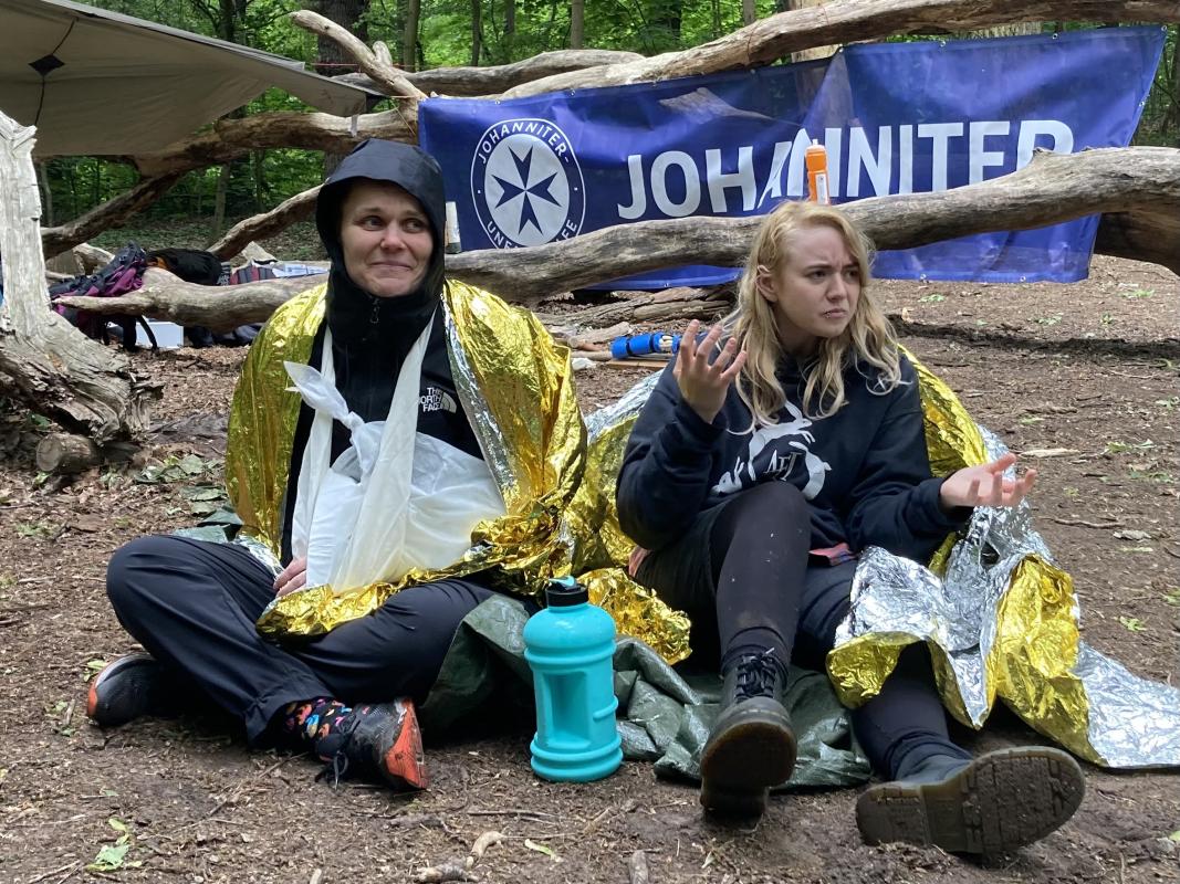 Forschende sitzen mit fiktiven Verletzungen in einem Workshop der Johanniter