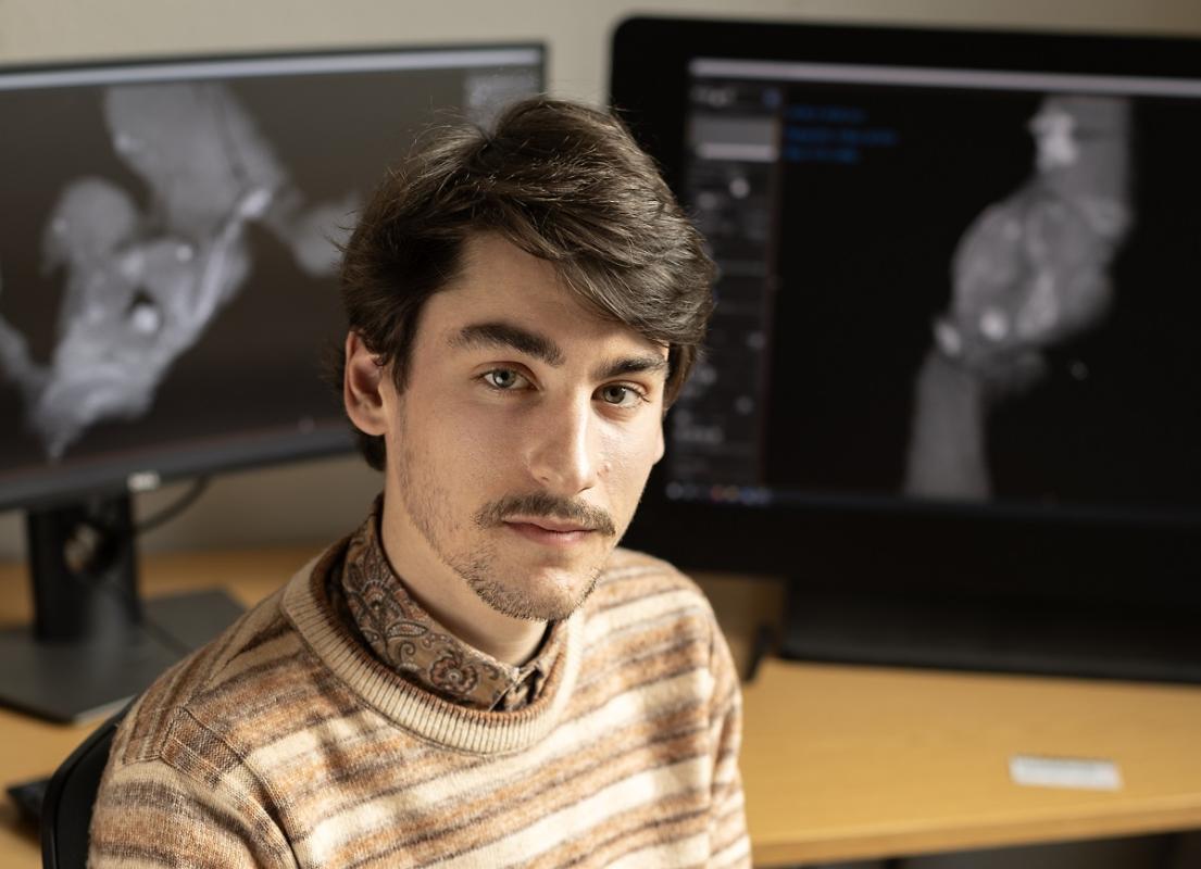 Arnaud Rebillard at his workplace, sitting in front of two computer screens.