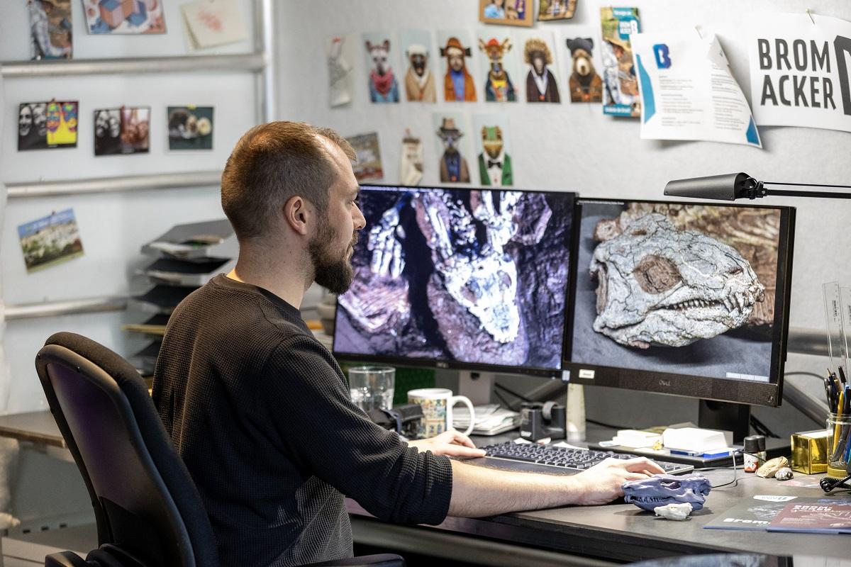 Steffen Bock sitting at his workplace in front of a computer at the Museum für Naturkunde Berlin.