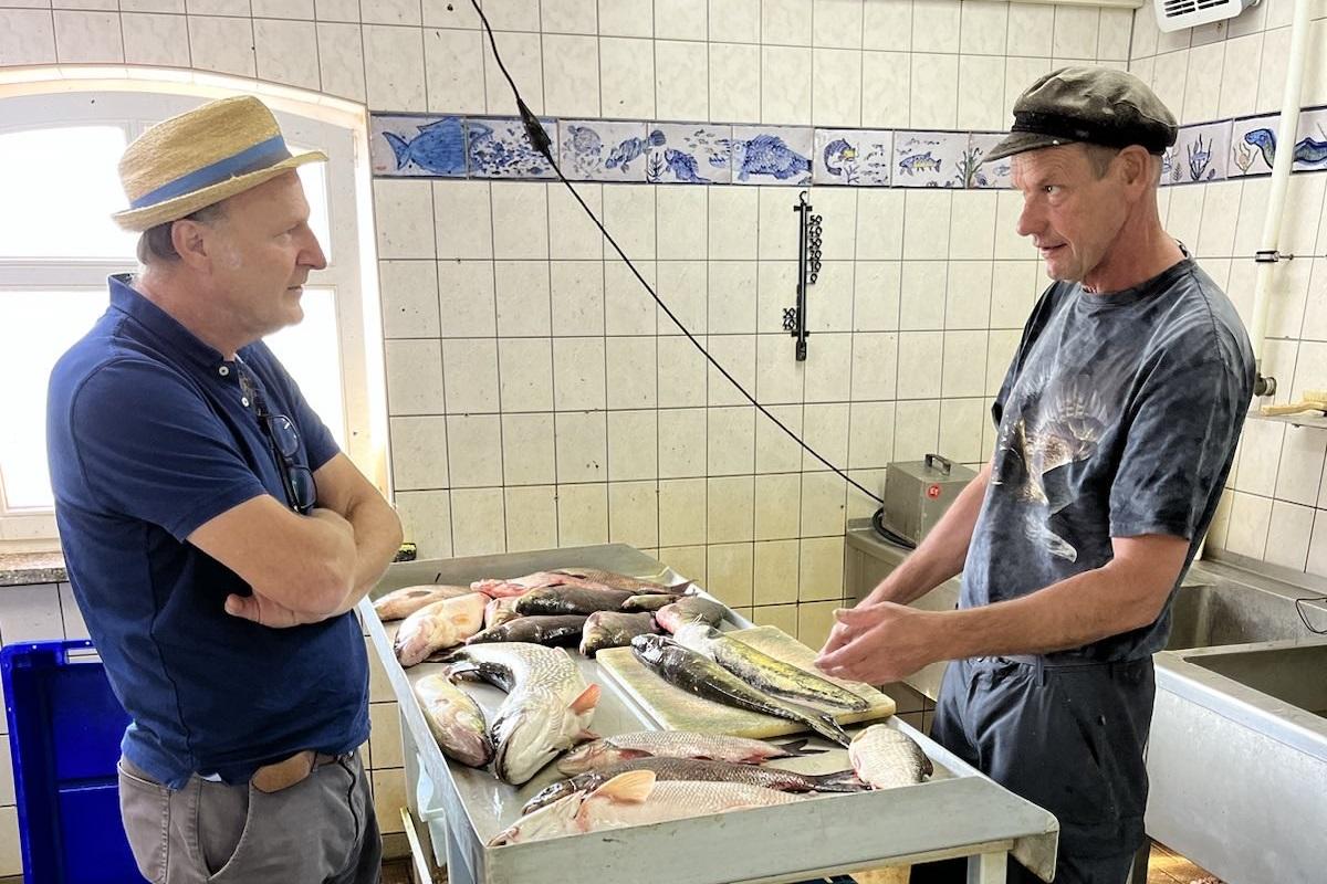 Ein Mitglied des Netzwerks kommt in der Fischerei mit einem lokalen Fischer ins Gespräch