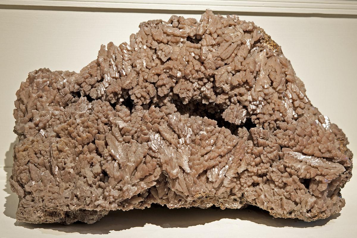 Das Foto zeigt ein 150 Kilogramm schweres Aggregat von stark glänzenden, braunen, hexagonalen Kristallen von Pyromorphit. Das Foto zeigt ein 150 Kilogramm schweres Aggregat von stark glänzenden, braunen, hexagonalen Kristallen von Pyromorphit.