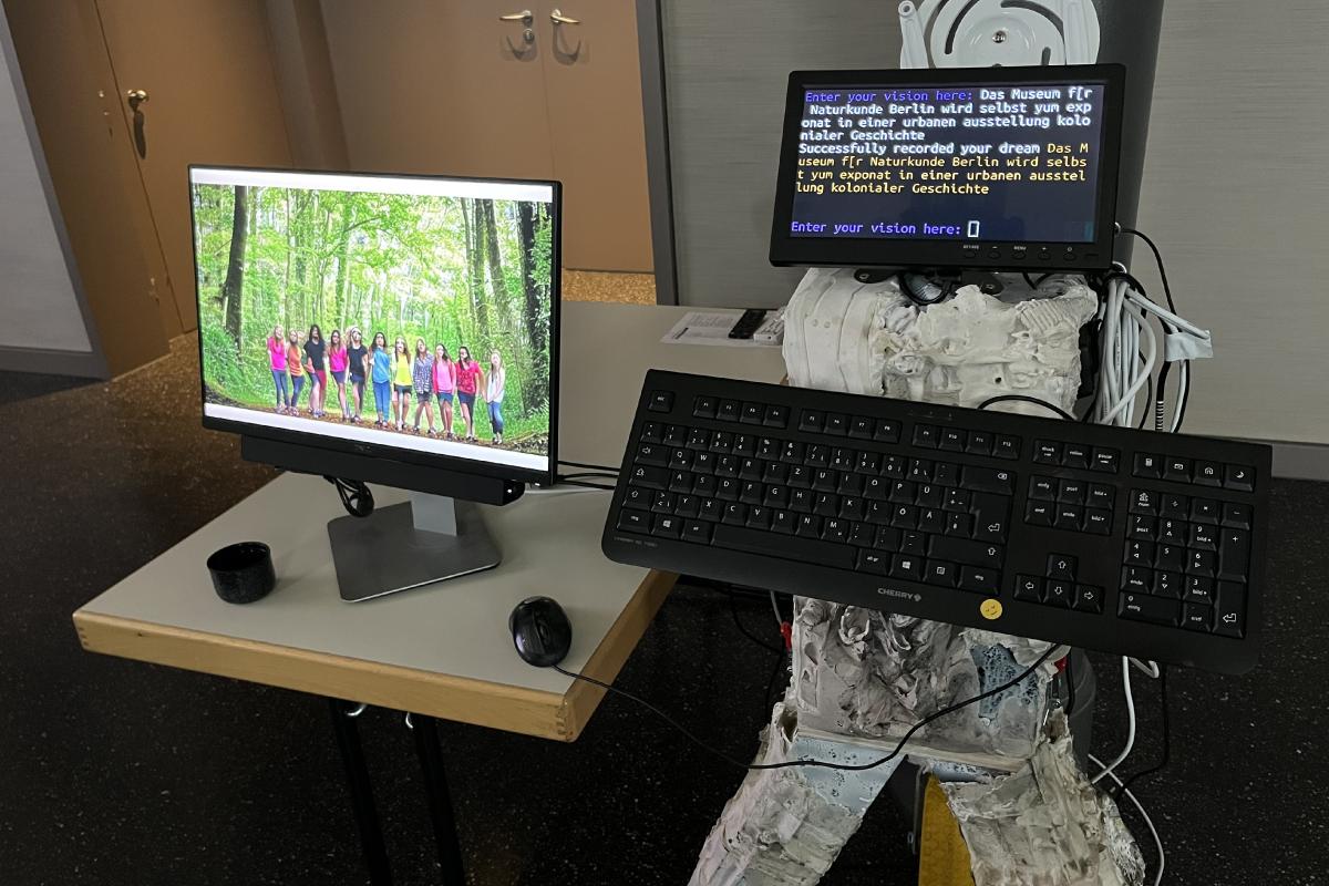 Eine Installation aus einem Bildschirm und einem Computer ermöglicht mithilfe von KI die Visionen der Workshop Teilnehmenden zu veranschaulichen.