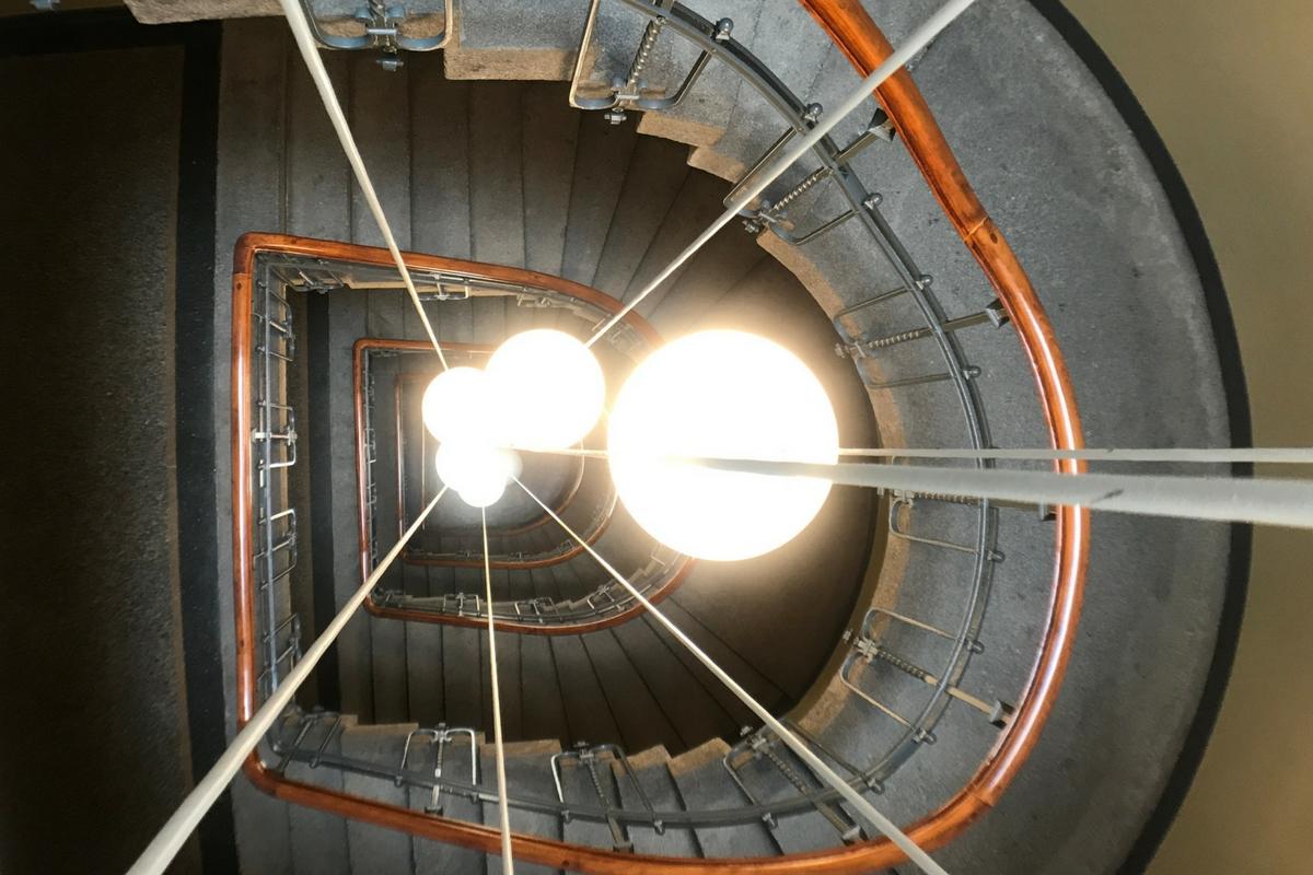 Ein spiralförmiges Treppenhaus mit Blick von oben nach unten.