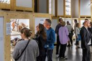 Foto der Ausstellung ZUGvögel mit mehreren Personen an diversen Vitrinen
