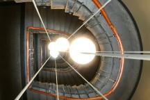 Ein spiralförmiges Treppenhaus mit Blick von oben nach unten.